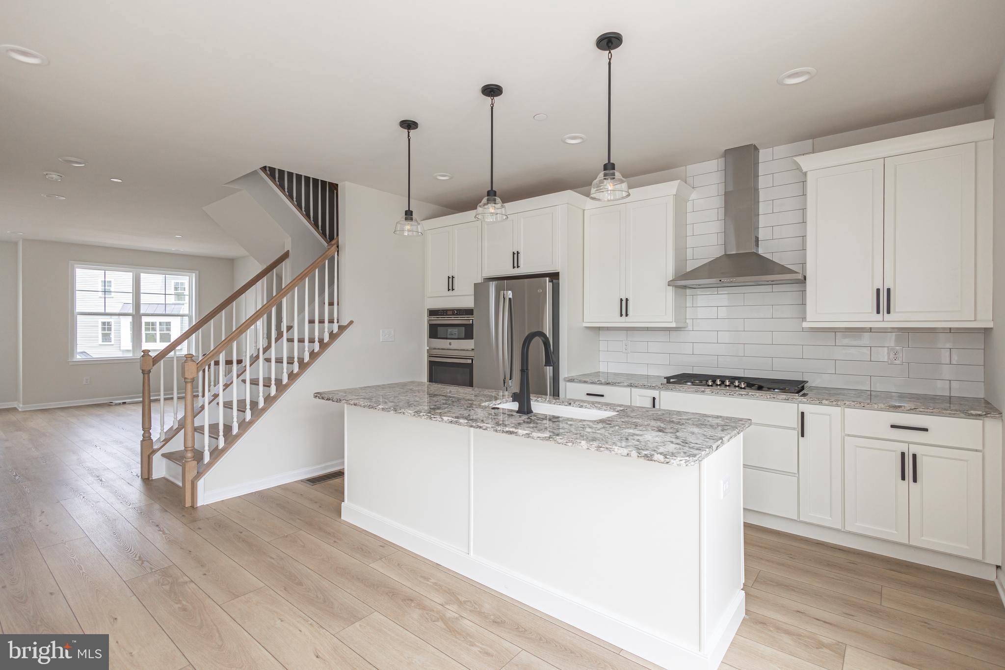 a view of kitchen with stainless steel appliances kitchen island sink stove and cabinets