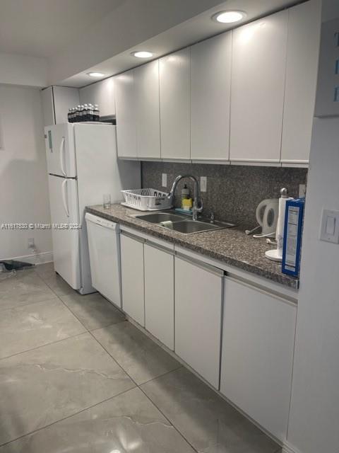 a kitchen with stainless steel appliances granite countertop a sink and a refrigerator