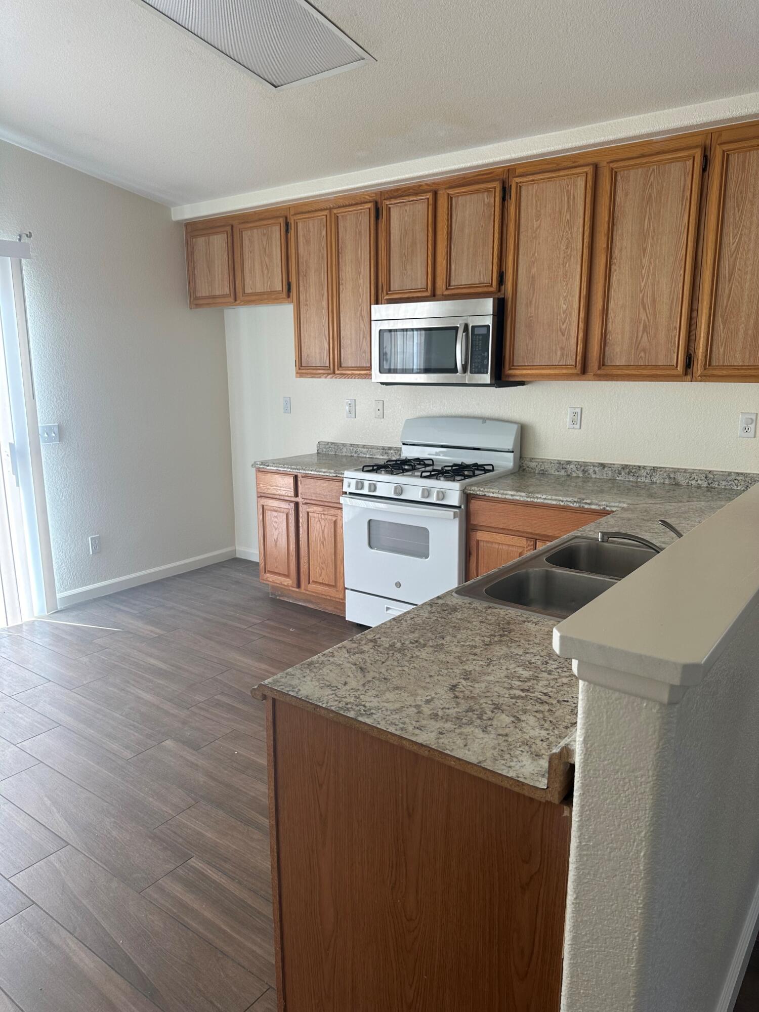 a kitchen with stainless steel appliances granite countertop a sink stove microwave and refrigerator