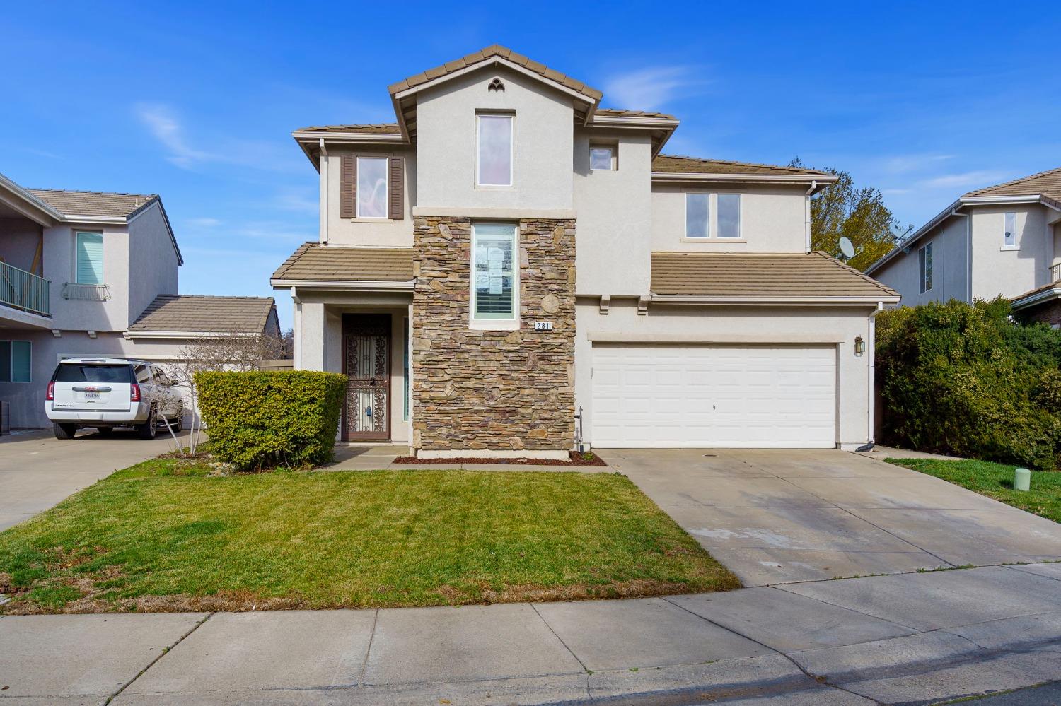 a front view of a house with a yard and garage