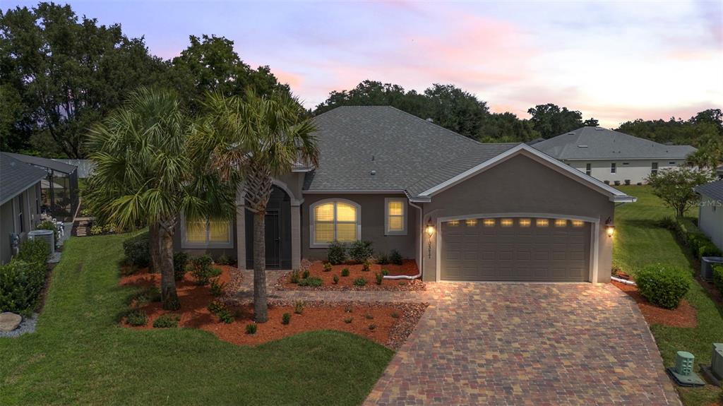 a front view of a house with a yard and tree s