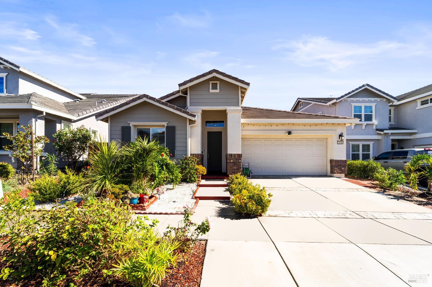 a front view of a house with a yard and potted plants