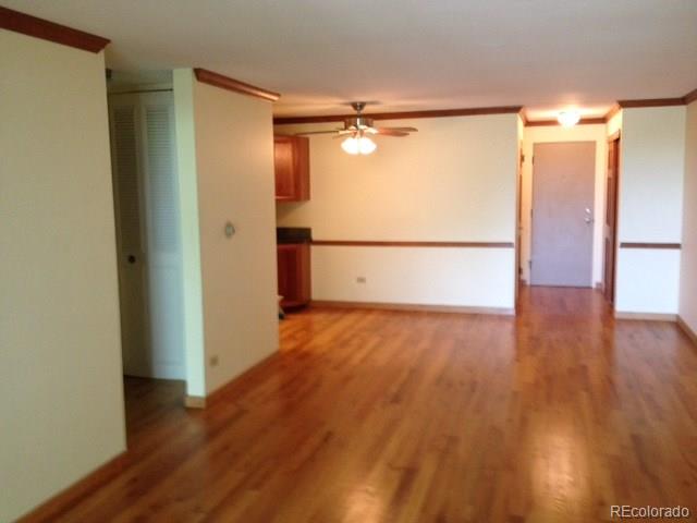 a view of empty room with wooden floor and fan