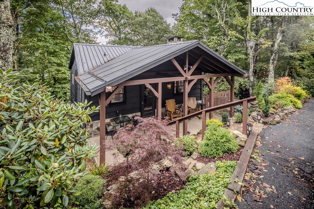 a view of house with wooden deck and trees around