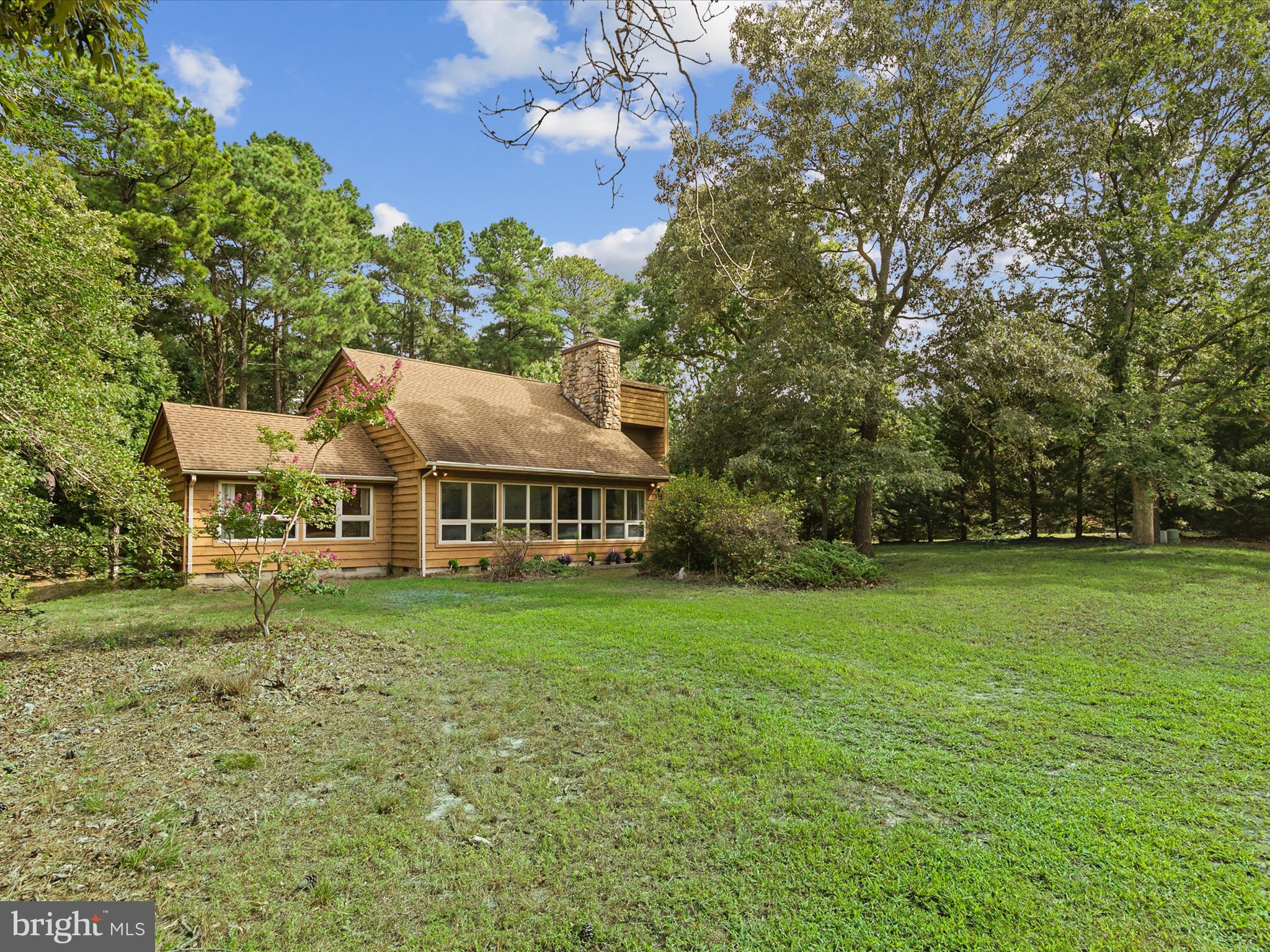 a view of a house with a big yard and large trees