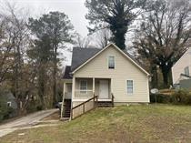 a view of a house with a yard and large tree