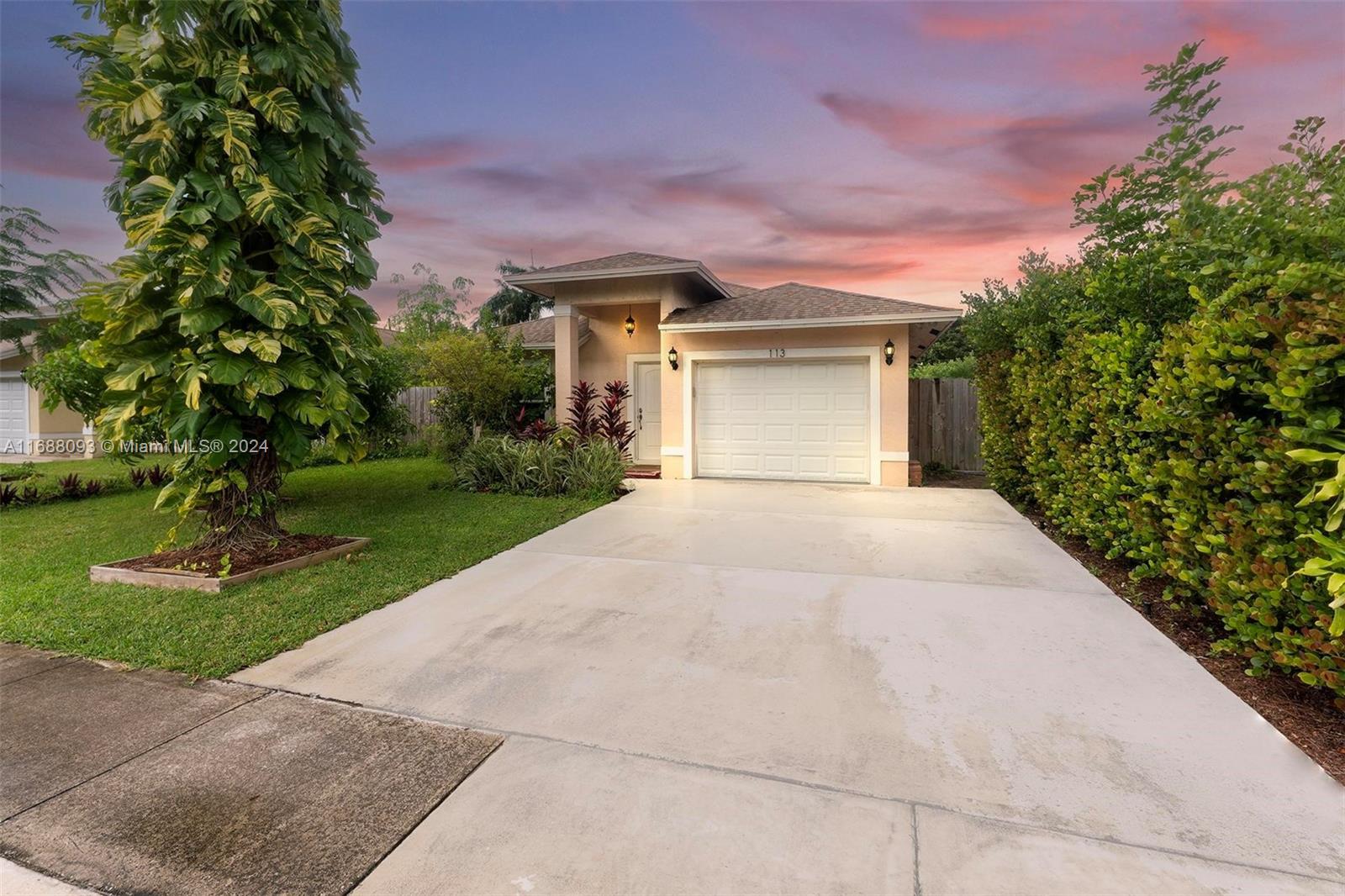 a front view of a house with a yard and a garage