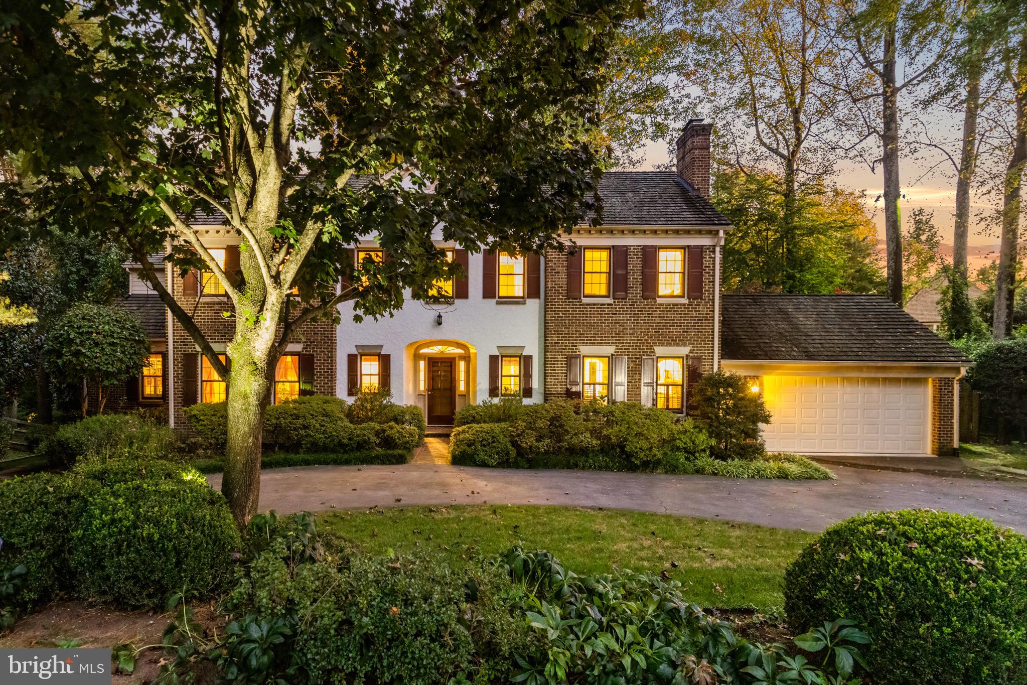 a front view of a house with a yard and trees