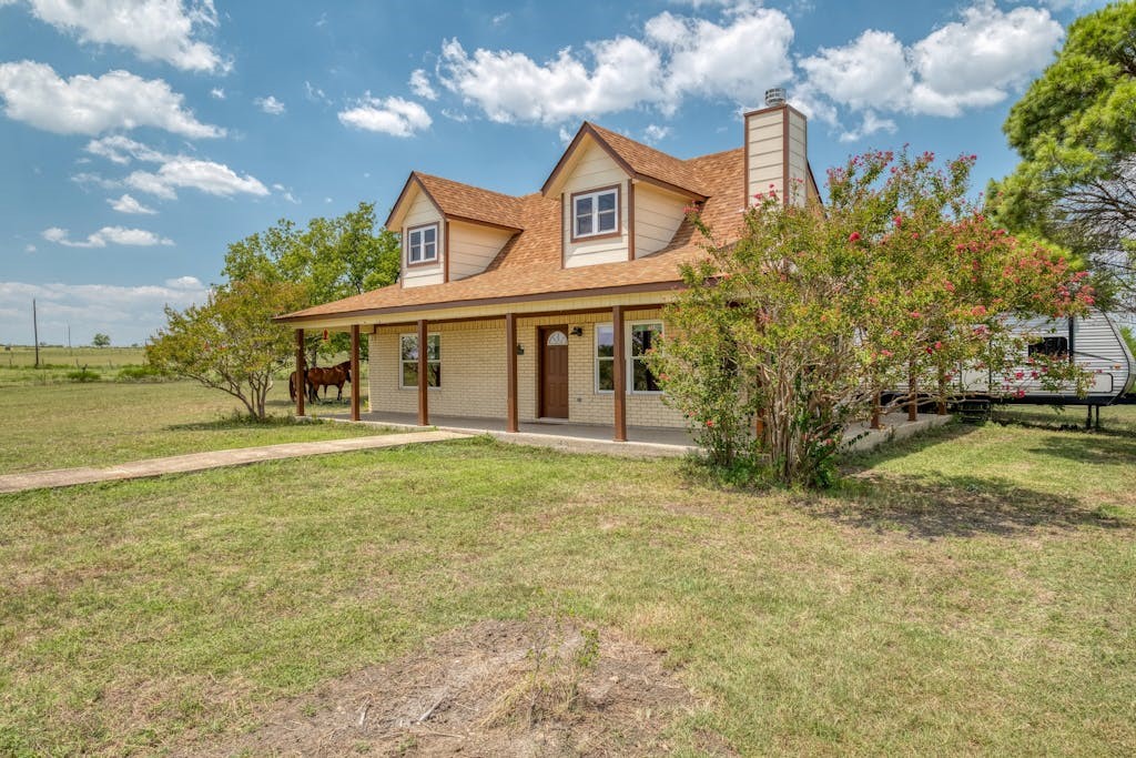 a view of a house with a yard and tree s