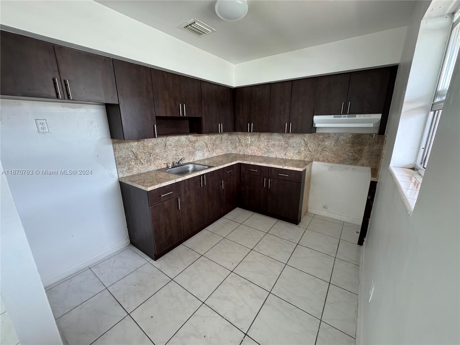 a kitchen with stainless steel appliances a sink a stove a refrigerator and cabinets