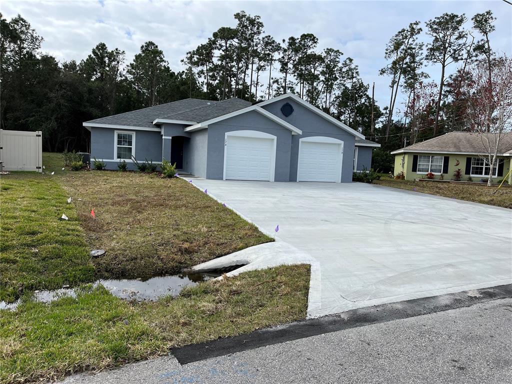 a front view of house with yard and trees in the background