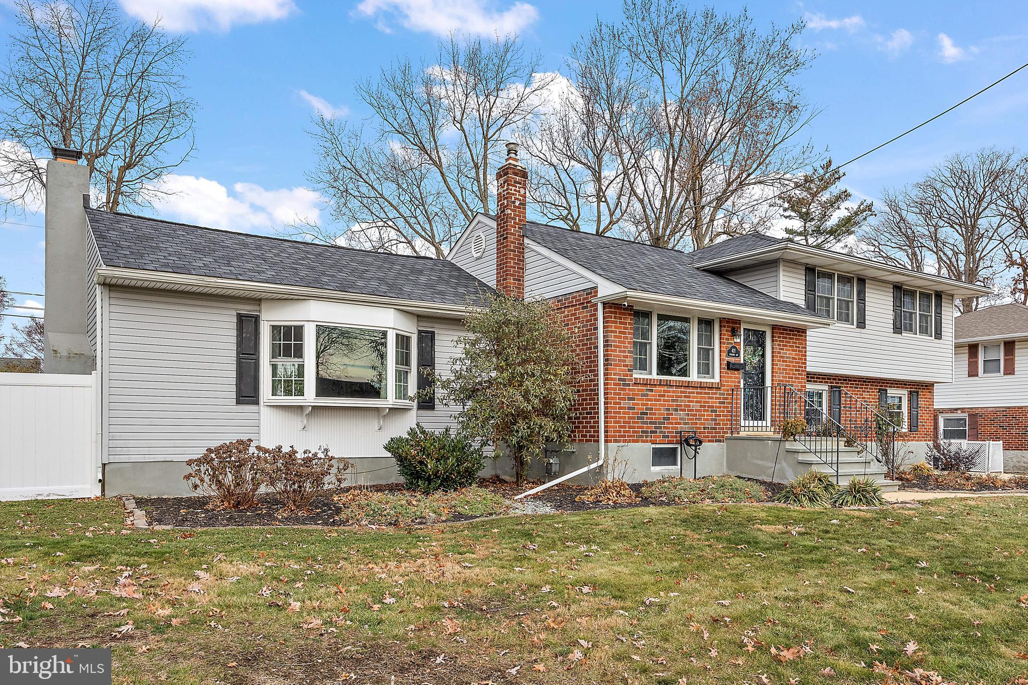 a front view of a house with a yard tree and outdoor seating