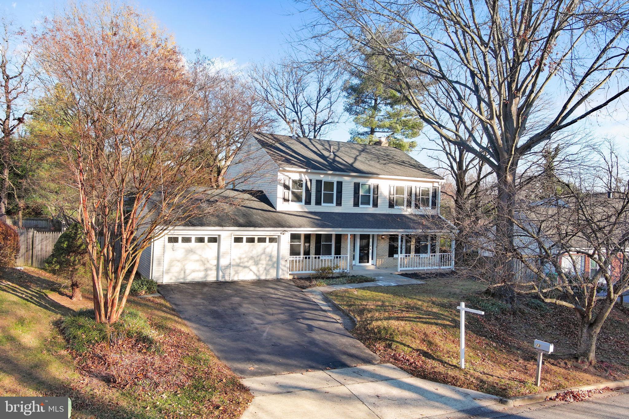 a front view of a house with a large tree