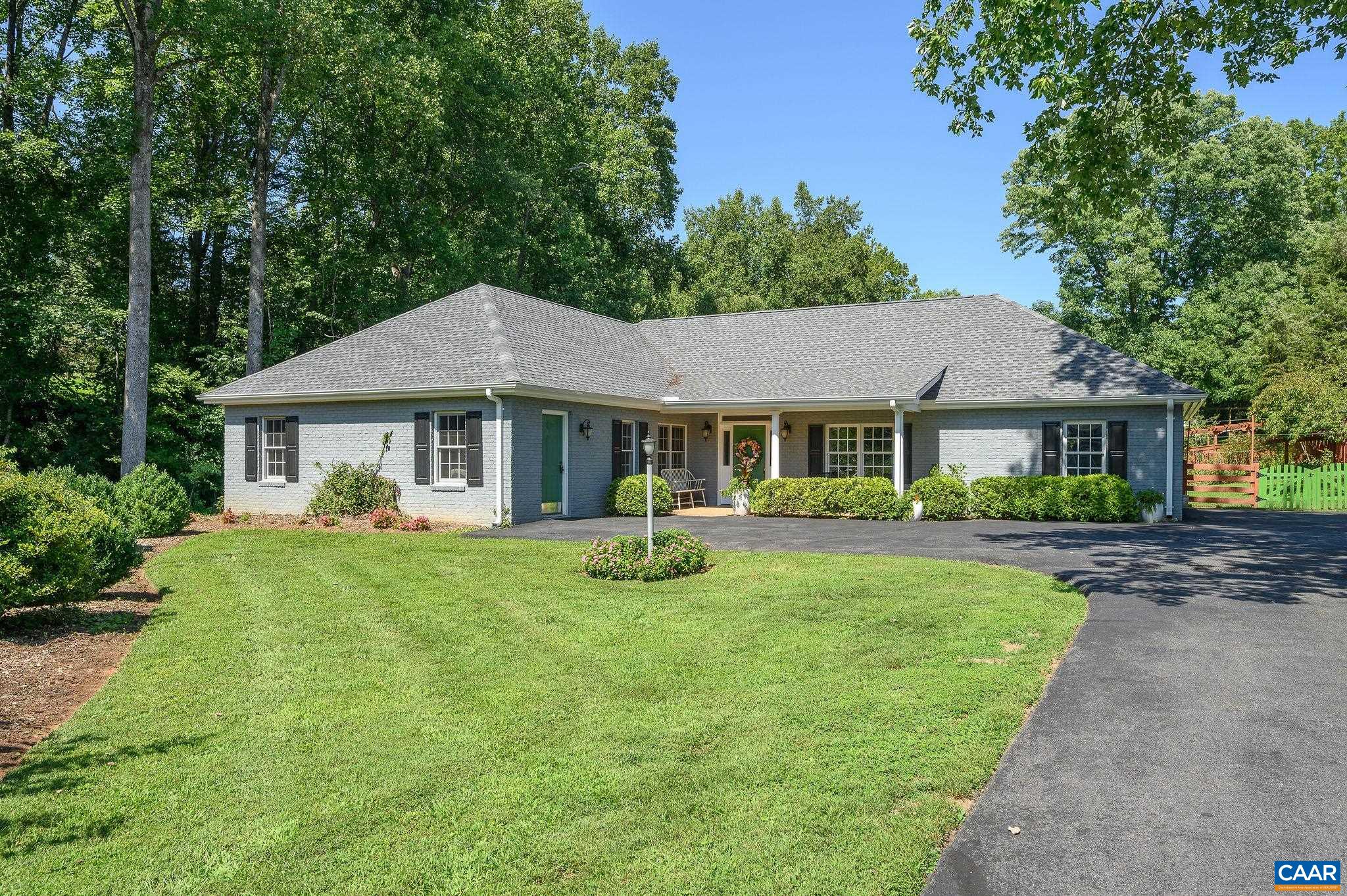 a front view of a house with yard and green space