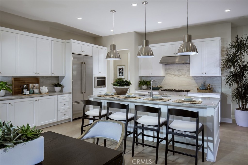 a kitchen with stainless steel appliances kitchen island a table and chairs in it