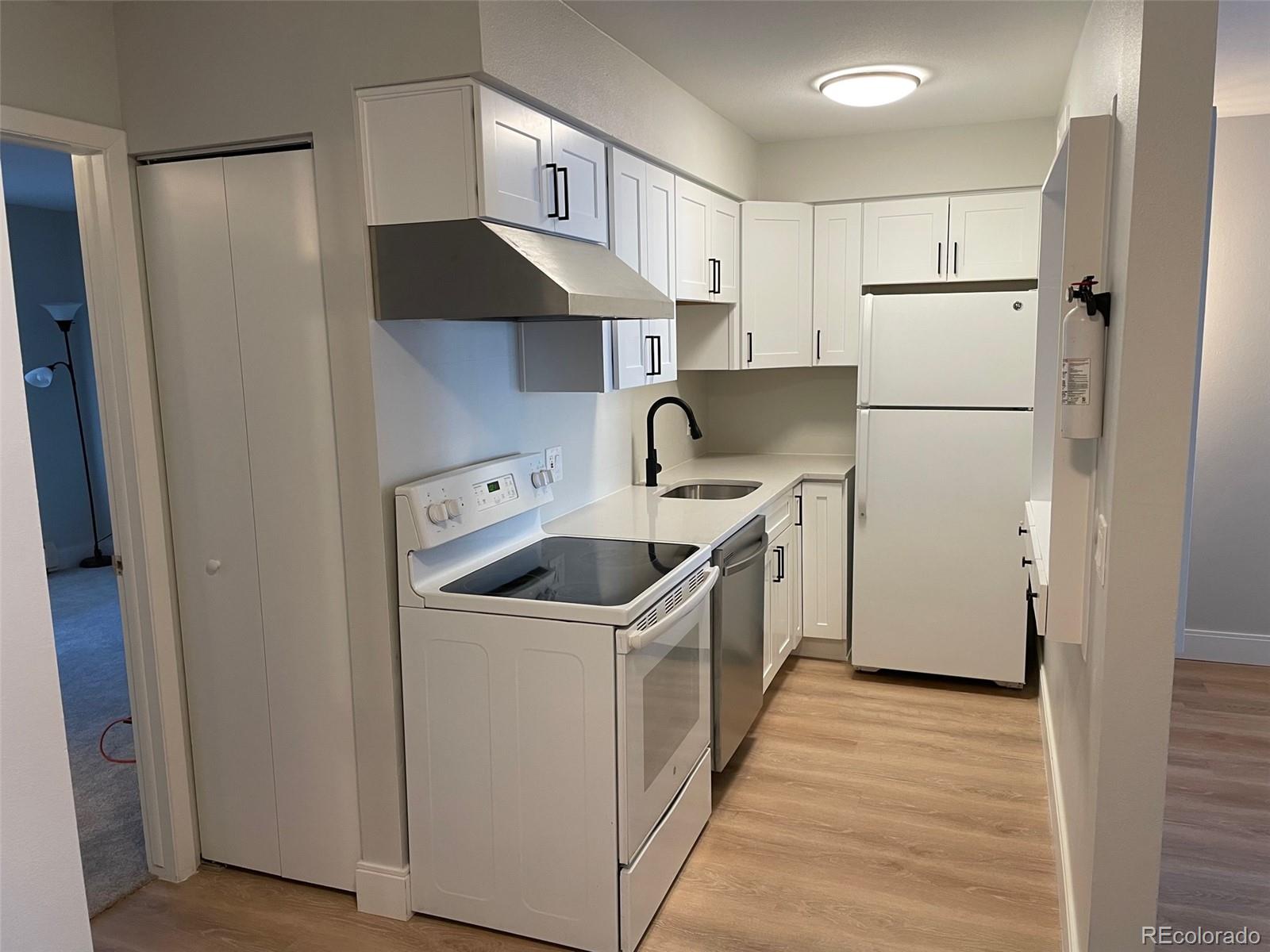 a kitchen with a stove a refrigerator and a sink