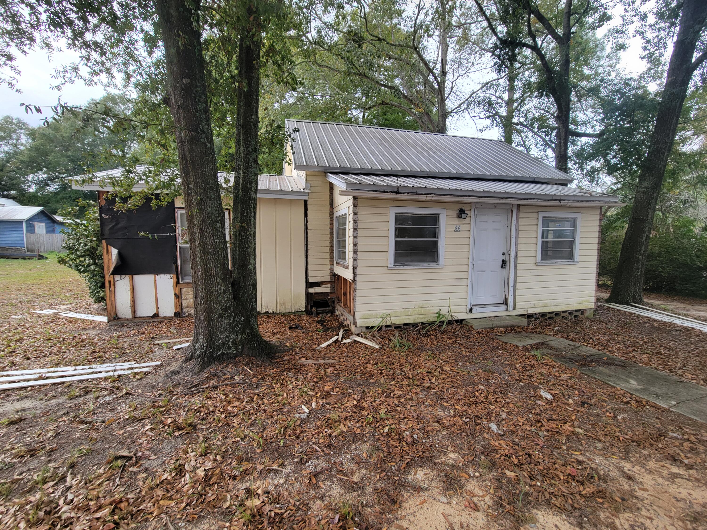 a view of a house with a yard and large tree