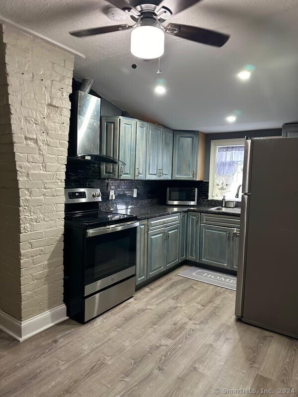 a kitchen with granite countertop a sink cabinets and stainless steel appliances