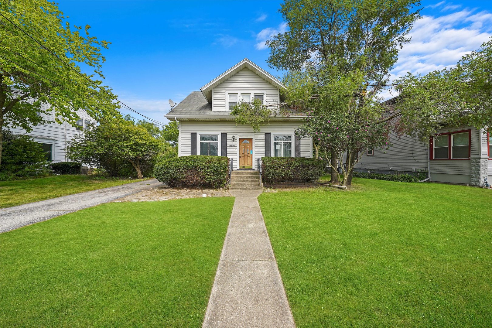 a front view of a house with a yard and trees