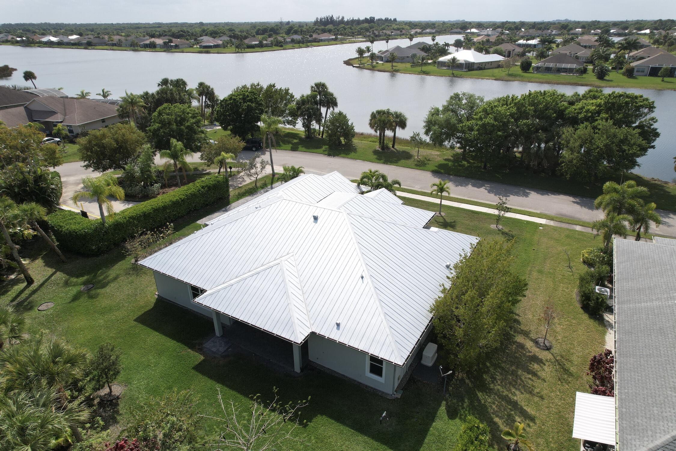 an aerial view of a house with outdoor space and lake view in back