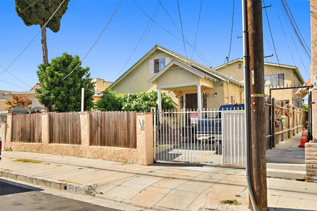 a view of a house with a small yard and wooden fence