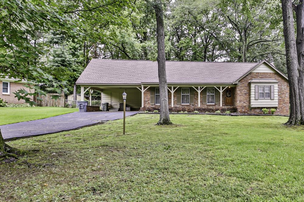 View of front facade featuring a carport and a front lawn