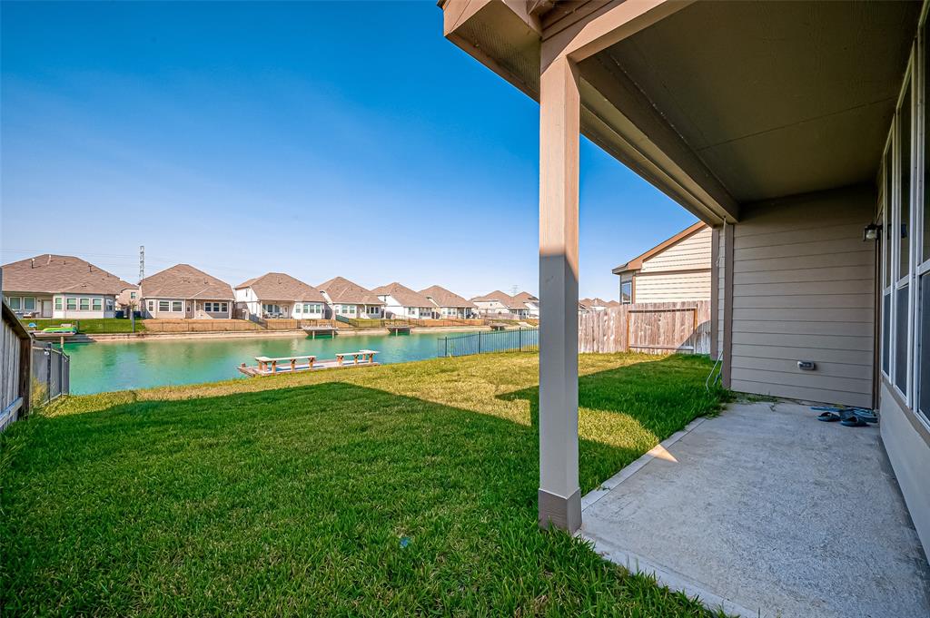 The backyard boasts a stunning view of the lake, where shimmering waters stretch out under the sun. A gentle breeze carries the scent of water and earth, enhancing the ultimate relaxation experience in this picturesque setting.