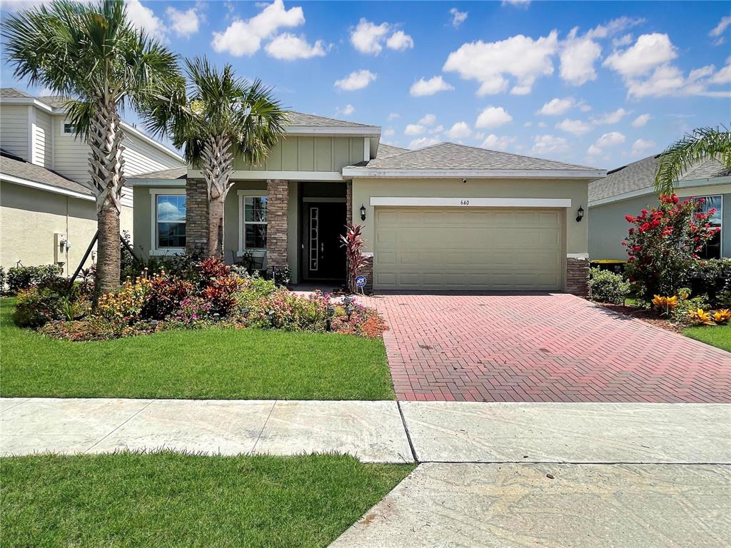 a front view of a house with a garden and yard