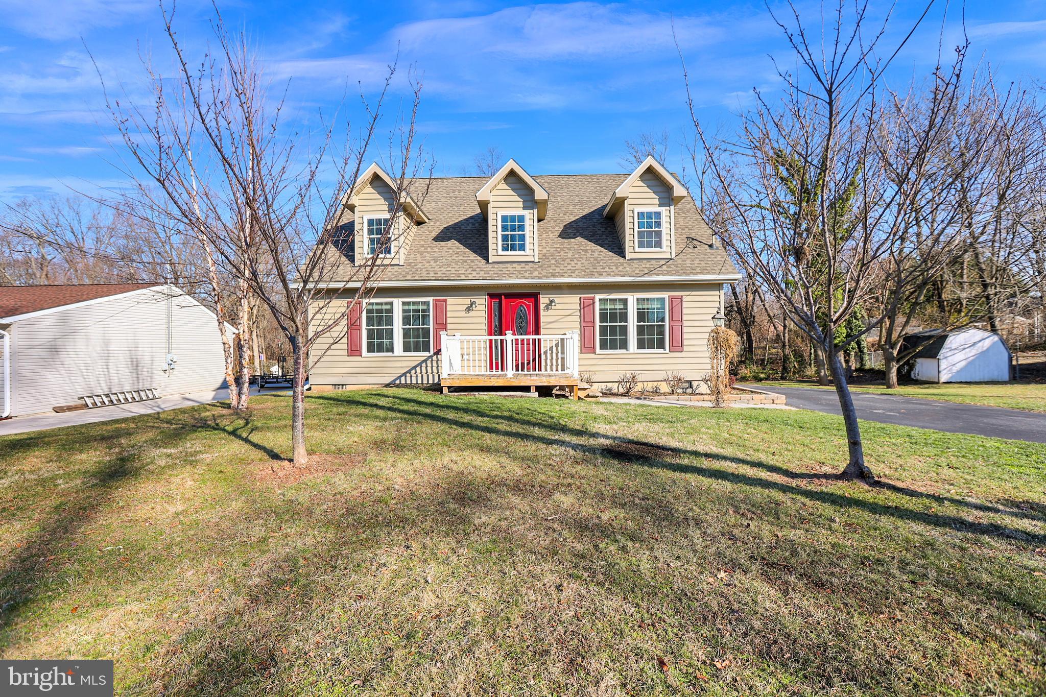 a view of an house with backyard and trees in the background