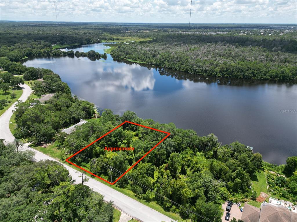 an aerial view of lake and residential houses with outdoor space