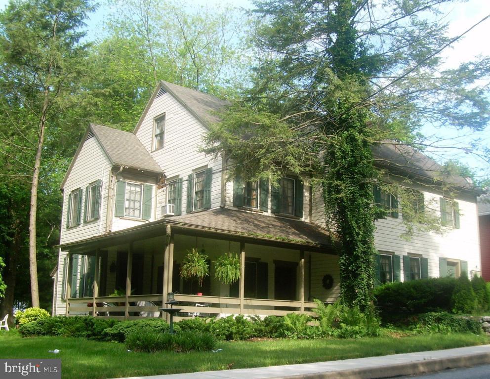 a view of a white house with large windows and a large tree