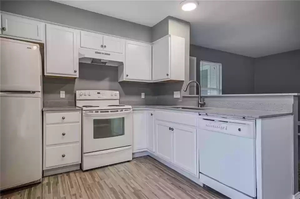 a kitchen with white cabinets and white appliances