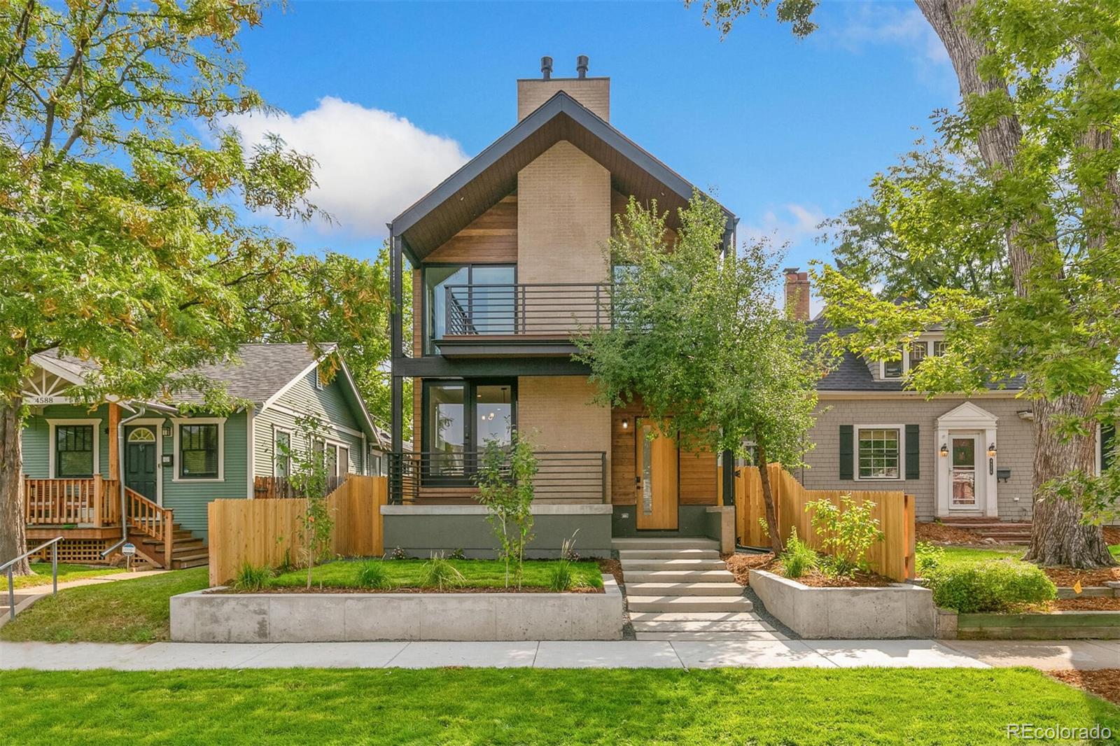 a front view of a house with a yard and potted plants