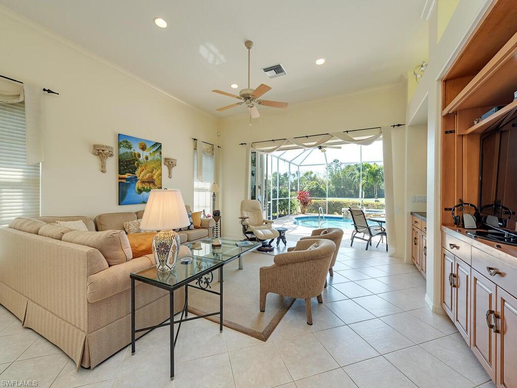 a living room with furniture a flat screen tv and a large window