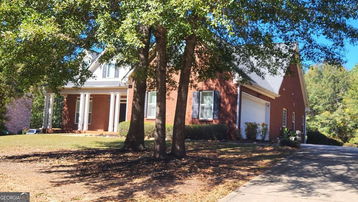 a view of a house with a tree in front of it