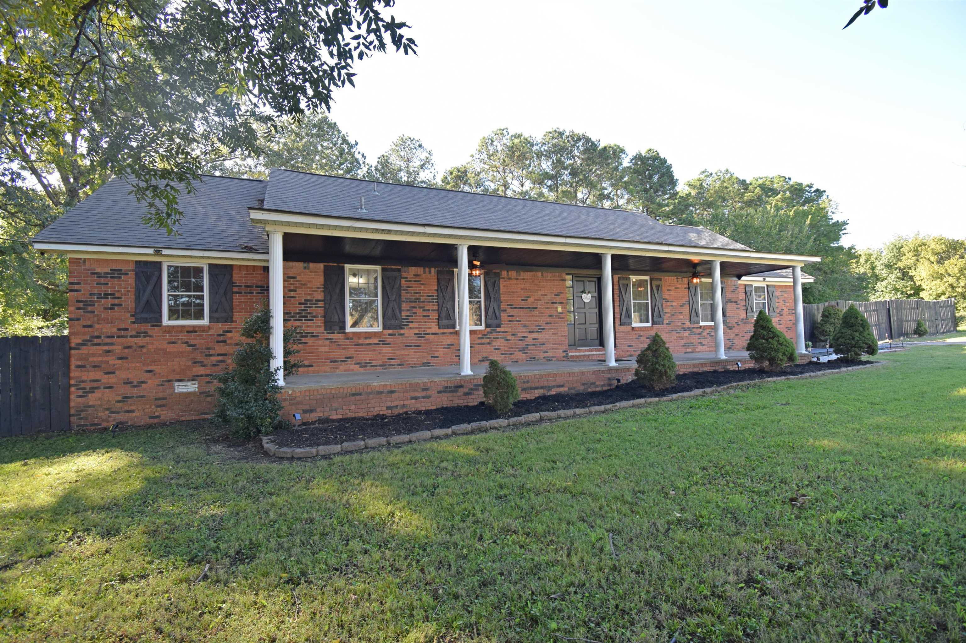 Single story home with a front lawn and covered porch