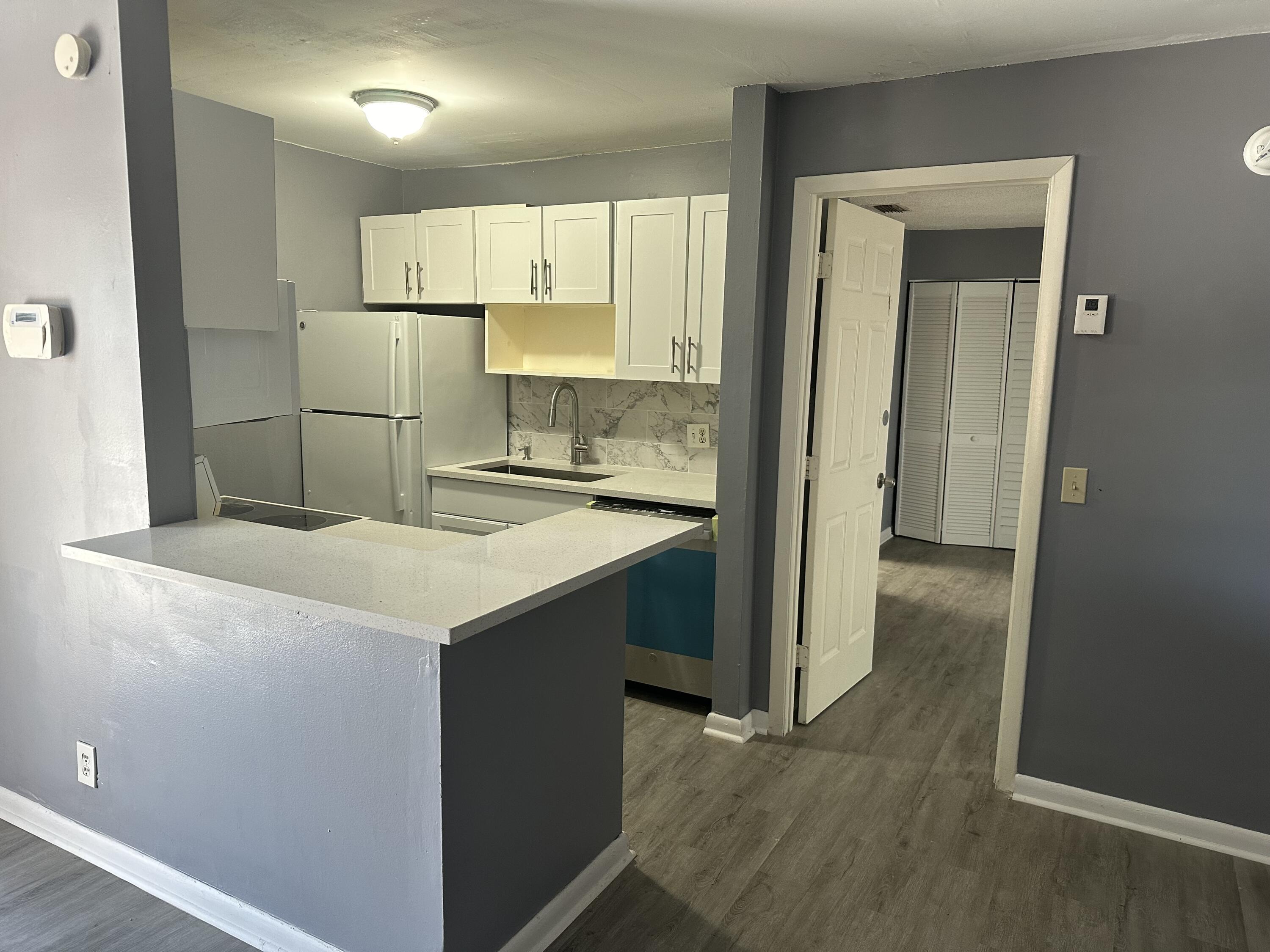 a kitchen with kitchen island a sink stove and refrigerator