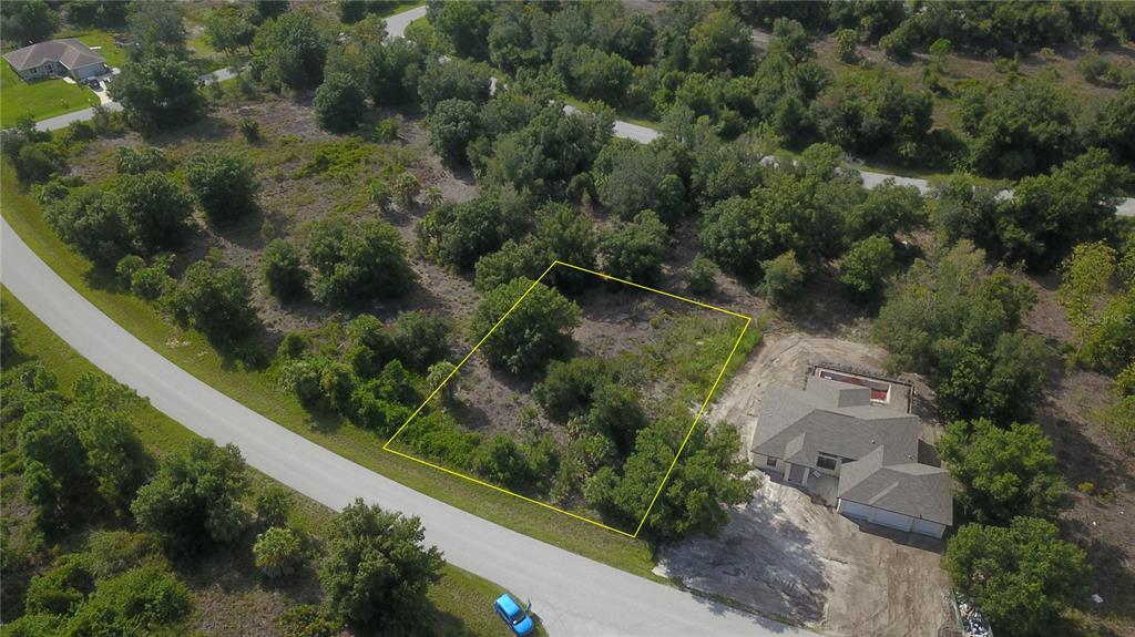 an aerial view of a house with a yard and lake view