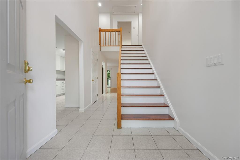 Staircase with a towering ceiling and tile patterned flooring