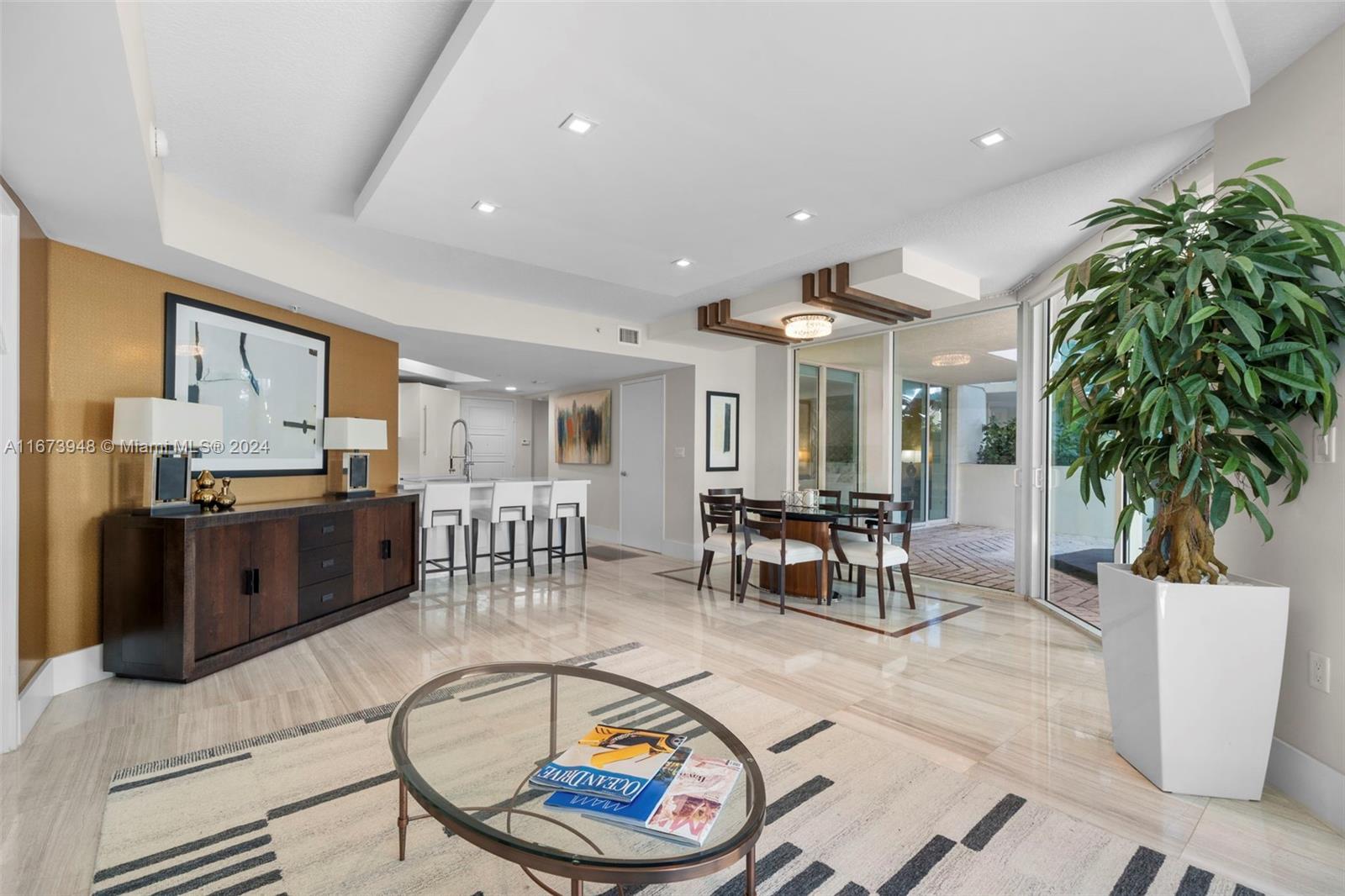 a living room with furniture a dining table and kitchen view with wooden floor