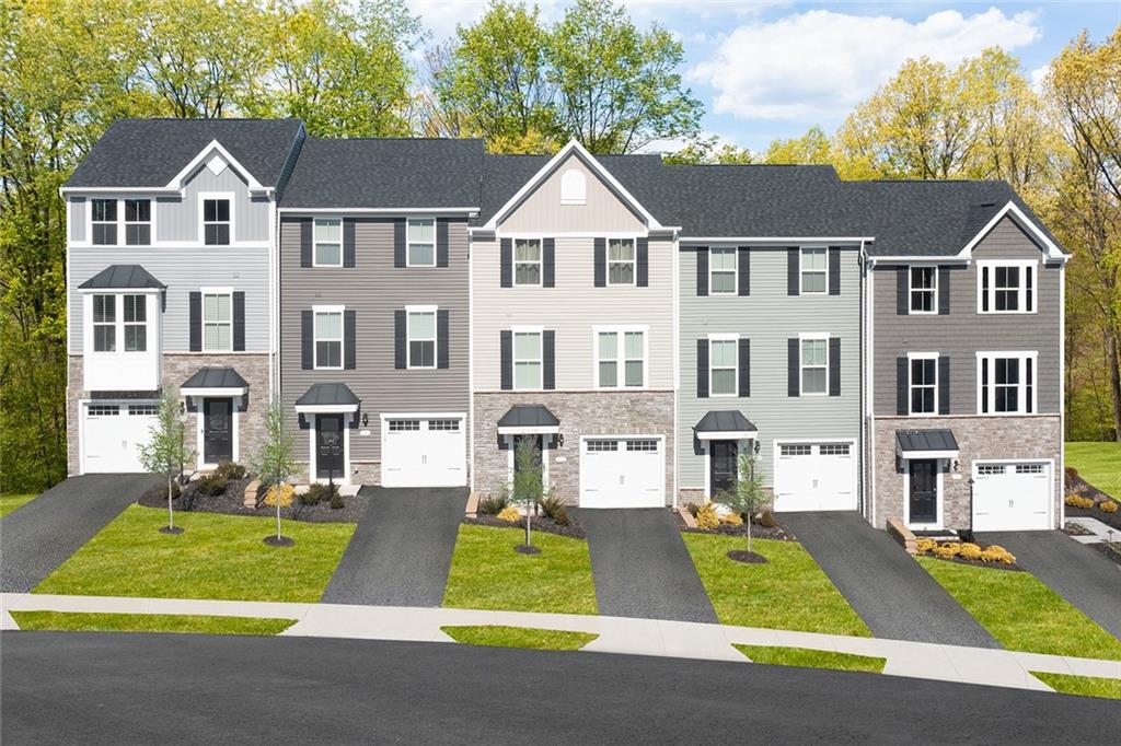 a front view of residential houses with yard and green space