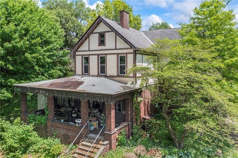 a aerial view of a house with table and chairs under an umbrella