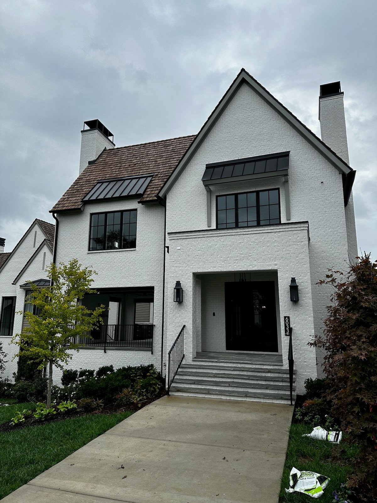 a front view of a house with a garden and plants