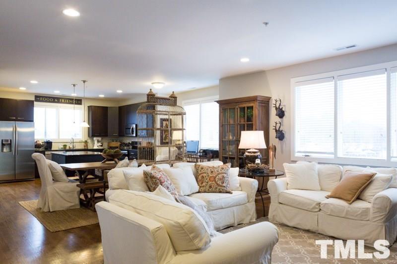 a living room with furniture kitchen view and large windows