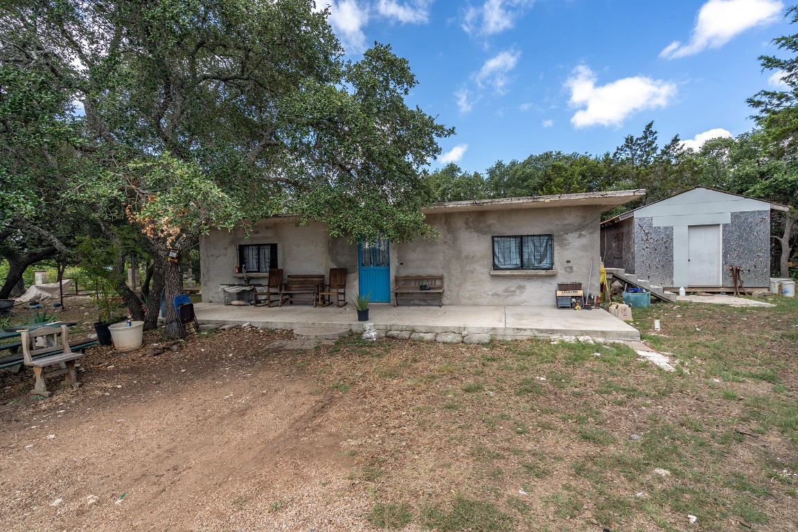 a view of a house with backyard and sitting area