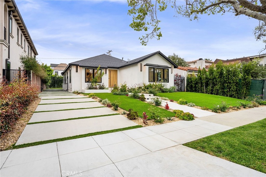 a front view of a house with a garden and yard