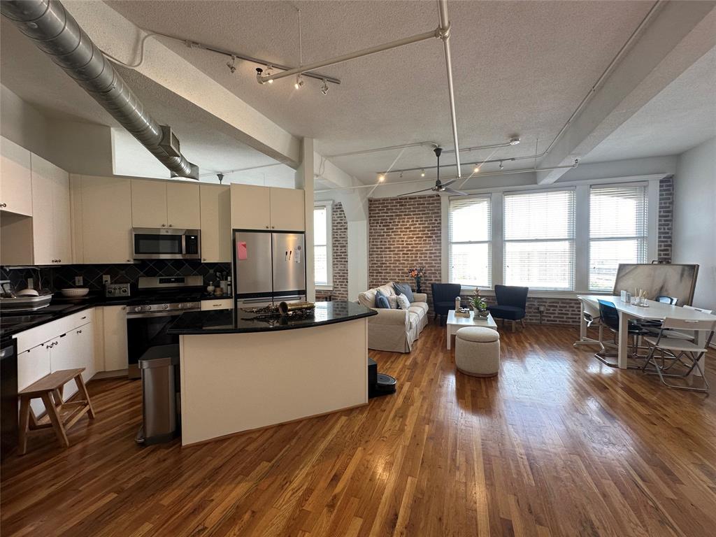 a kitchen with a sink dishwasher stove and white cabinets with wooden floor