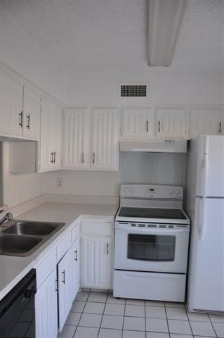 a kitchen with cabinets appliances and a sink