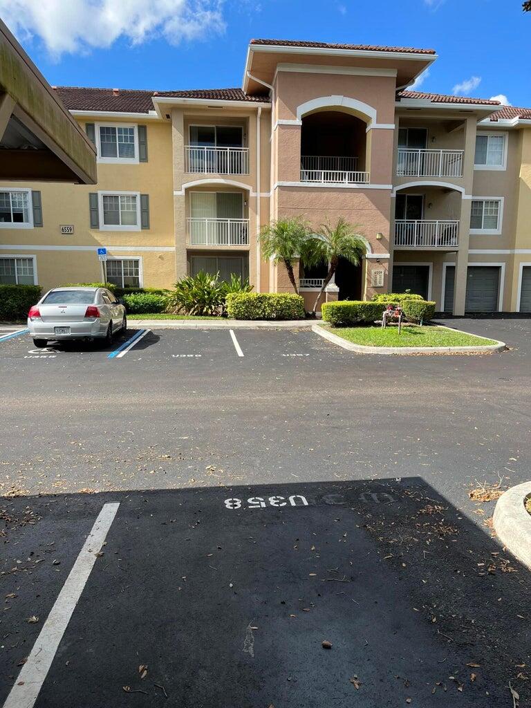 a front view of a building with cars parked