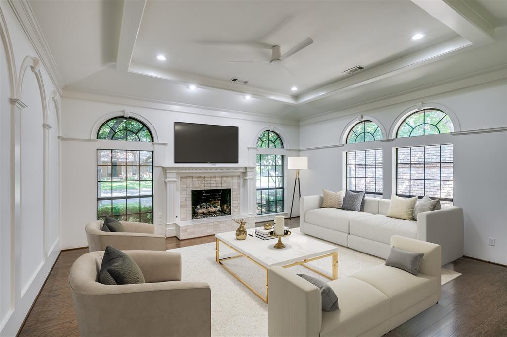 a living room with furniture a fireplace and a floor to ceiling window